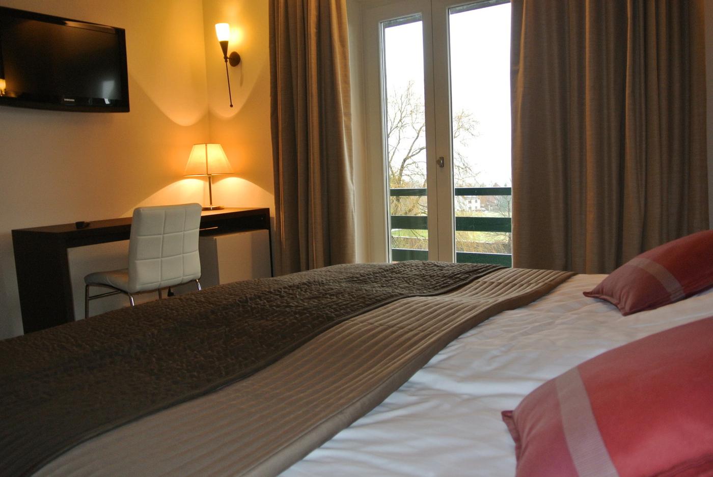 Kamer met bureau, flatscreen en balkondeuren